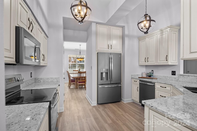 kitchen featuring light stone countertops, a chandelier, decorative light fixtures, and appliances with stainless steel finishes