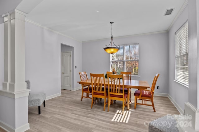 dining room featuring light hardwood / wood-style floors, ornate columns, plenty of natural light, and ornamental molding