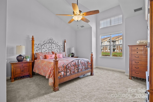 carpeted bedroom with ceiling fan and high vaulted ceiling