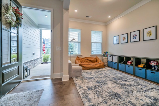 playroom featuring ornamental molding and dark wood-type flooring