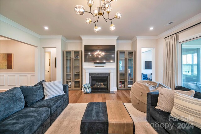 living room with ornamental molding and light hardwood / wood-style flooring