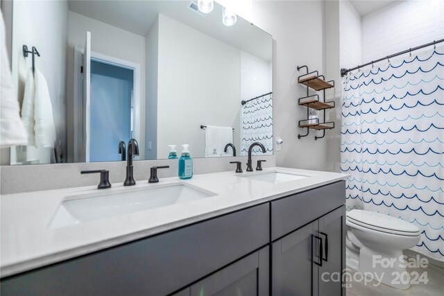 bathroom featuring toilet, a shower with curtain, and vanity