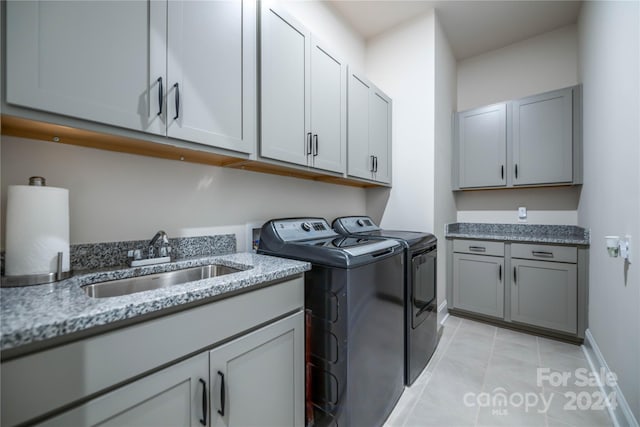 laundry area with cabinets, light tile patterned flooring, sink, and independent washer and dryer