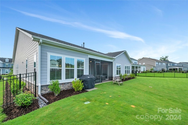 back of house featuring a sunroom and a yard