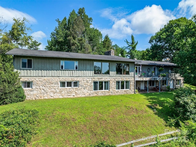 rear view of property with a lawn