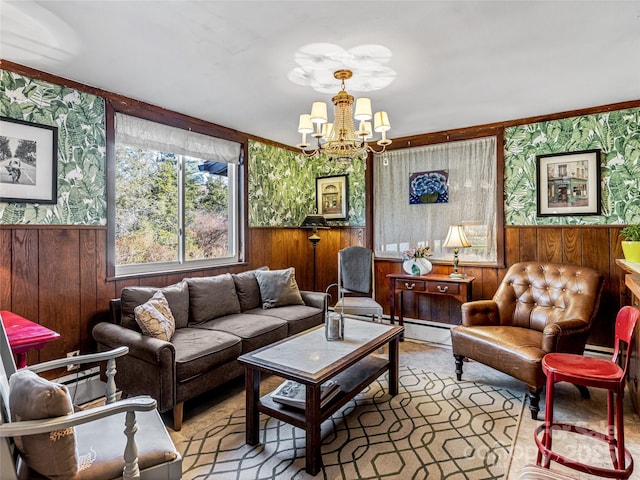 living room featuring an inviting chandelier, ornamental molding, and wooden walls