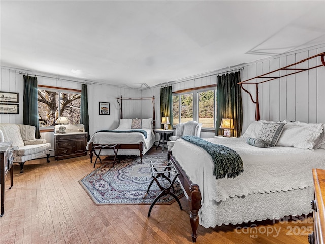 bedroom featuring hardwood / wood-style flooring and wood walls