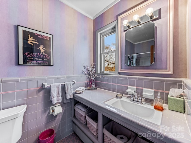 bathroom featuring sink, tile walls, toilet, and ornamental molding