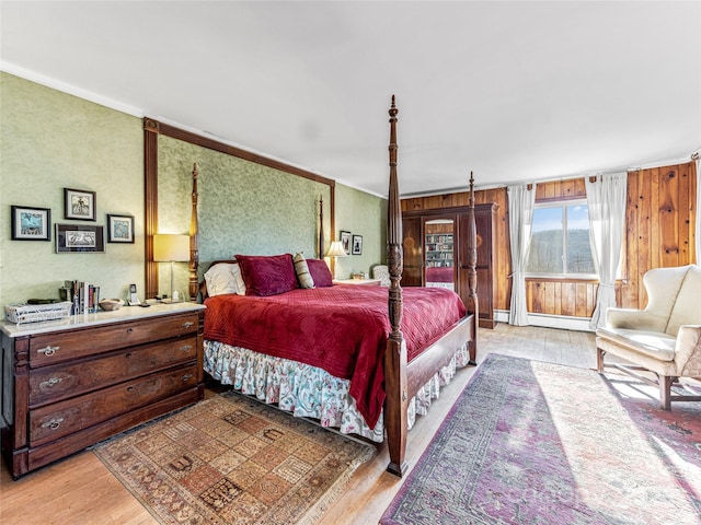 bedroom with wood walls, light hardwood / wood-style flooring, and crown molding