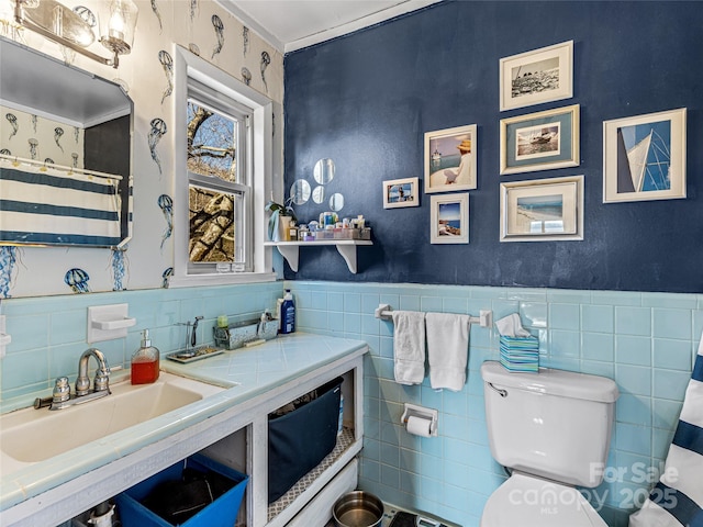 bathroom with sink, tile walls, toilet, and walk in shower