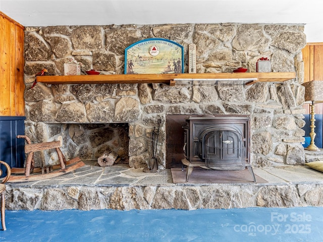 room details featuring concrete floors, wood walls, and a wood stove