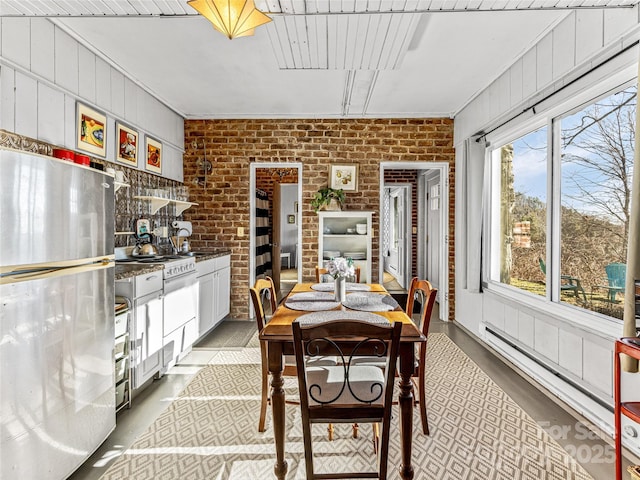 dining space with brick wall and a baseboard radiator