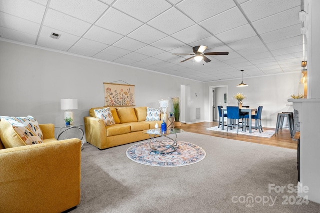 living room featuring light hardwood / wood-style flooring, a paneled ceiling, ornamental molding, and ceiling fan