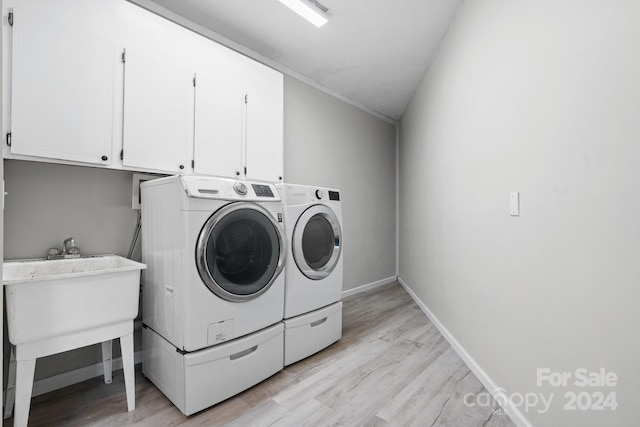 laundry room with cabinets, light hardwood / wood-style flooring, and separate washer and dryer