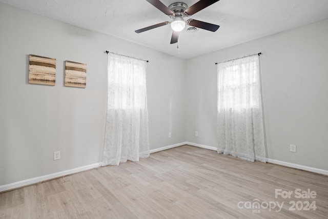 empty room featuring light wood-type flooring and ceiling fan