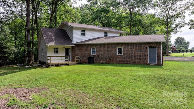 back of house featuring central AC unit and a yard