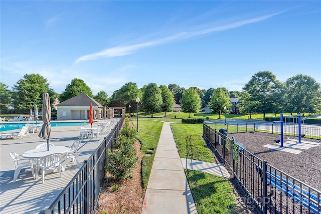 surrounding community featuring a patio area, a swimming pool, and a lawn