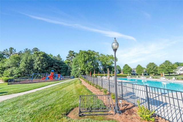 view of pool featuring a playground and a lawn