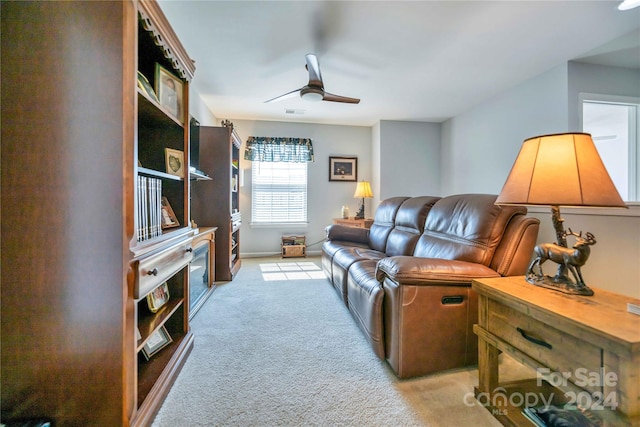 carpeted living room with ceiling fan