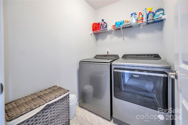 clothes washing area featuring light tile patterned floors and independent washer and dryer