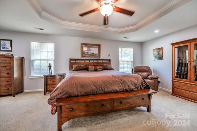 bedroom with ceiling fan, a raised ceiling, ornamental molding, and light carpet