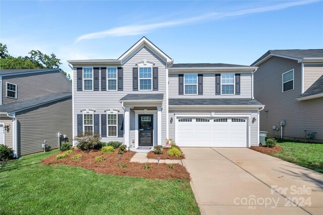 view of front of home with a garage and a front lawn