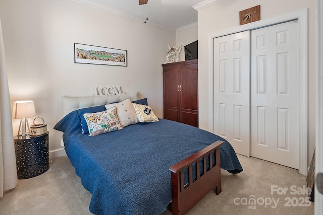 carpeted bedroom featuring ceiling fan, a closet, and ornamental molding