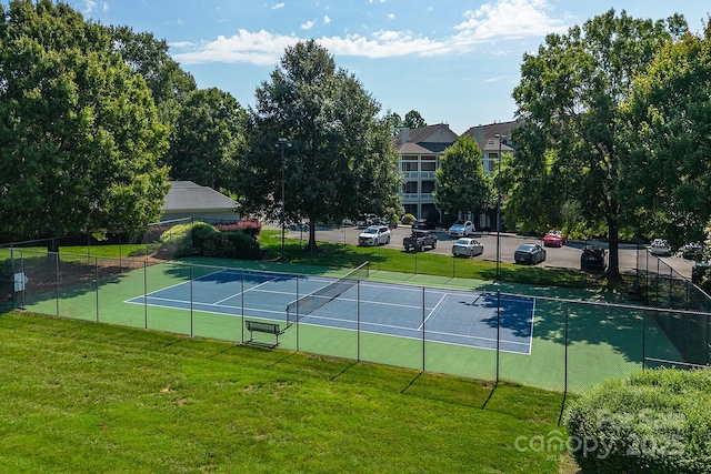 view of tennis court with a yard