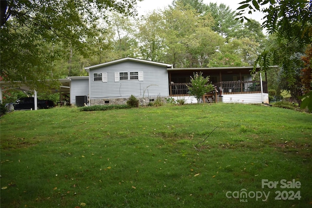 back of property featuring cooling unit and a lawn