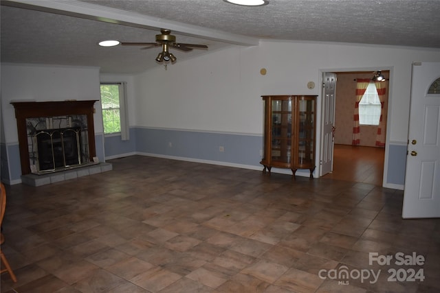 unfurnished living room with vaulted ceiling with beams, a fireplace, a textured ceiling, and ceiling fan