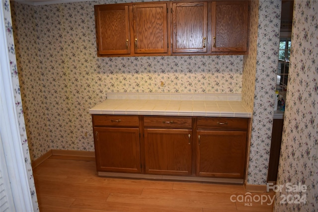 kitchen with light hardwood / wood-style flooring and tile counters