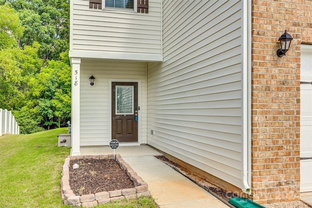 entrance to property with a lawn