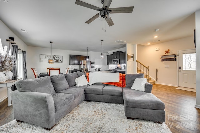 living room with ceiling fan and wood-type flooring