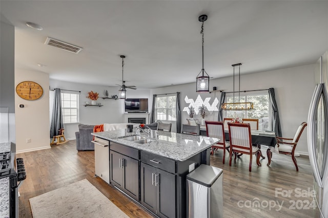 kitchen with an island with sink, dark hardwood / wood-style floors, sink, and dishwasher