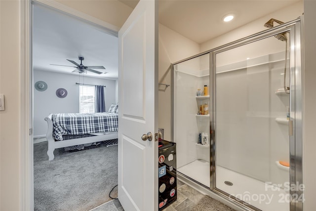 bathroom featuring ceiling fan and a shower with door