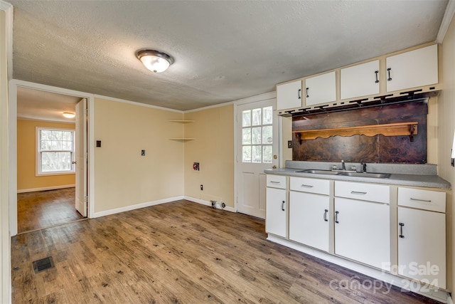 kitchen featuring light hardwood / wood-style flooring, sink, white cabinets, and crown molding