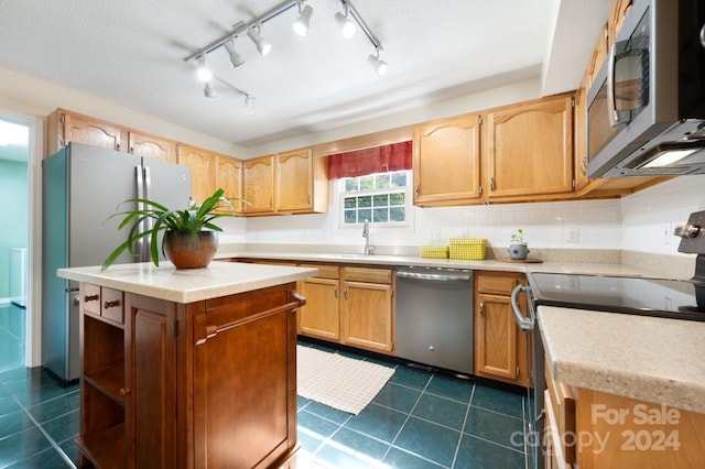 kitchen with tasteful backsplash, stainless steel appliances, dark tile patterned flooring, and rail lighting