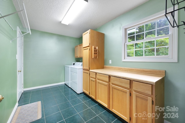 laundry room featuring cabinets, a textured ceiling, dark tile patterned flooring, and independent washer and dryer