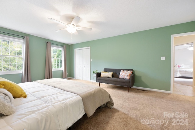 bedroom with light carpet, a closet, and ceiling fan