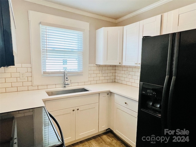 kitchen with sink, crown molding, white cabinetry, decorative backsplash, and black fridge with ice dispenser