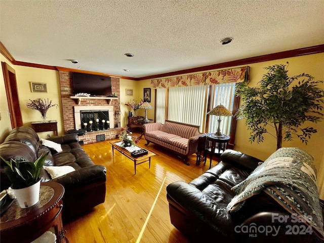 living area with ornamental molding, a fireplace, a textured ceiling, and wood finished floors