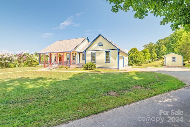 view of front of home featuring a porch, a shed, a front yard, central air condition unit, and a garage