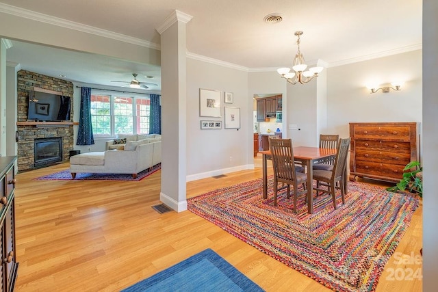 dining area with crown molding, a fireplace, ceiling fan with notable chandelier, and hardwood / wood-style floors