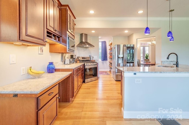 kitchen with appliances with stainless steel finishes, pendant lighting, sink, light stone countertops, and wall chimney exhaust hood