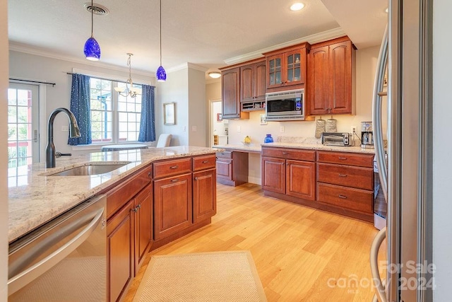 kitchen with sink, decorative light fixtures, light wood-type flooring, ornamental molding, and stainless steel appliances