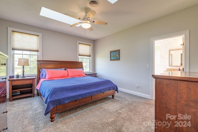 bedroom with ceiling fan, a skylight, and light carpet