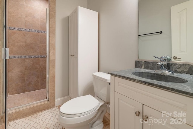 bathroom with vanity, an enclosed shower, and toilet