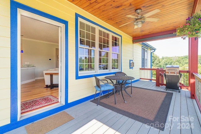 wooden deck featuring a grill and ceiling fan