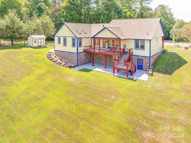 rear view of house with a shed, a wooden deck, a yard, and a patio