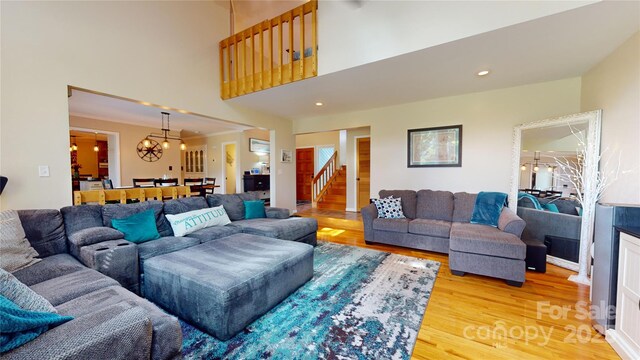 living room featuring light wood-type flooring and a notable chandelier